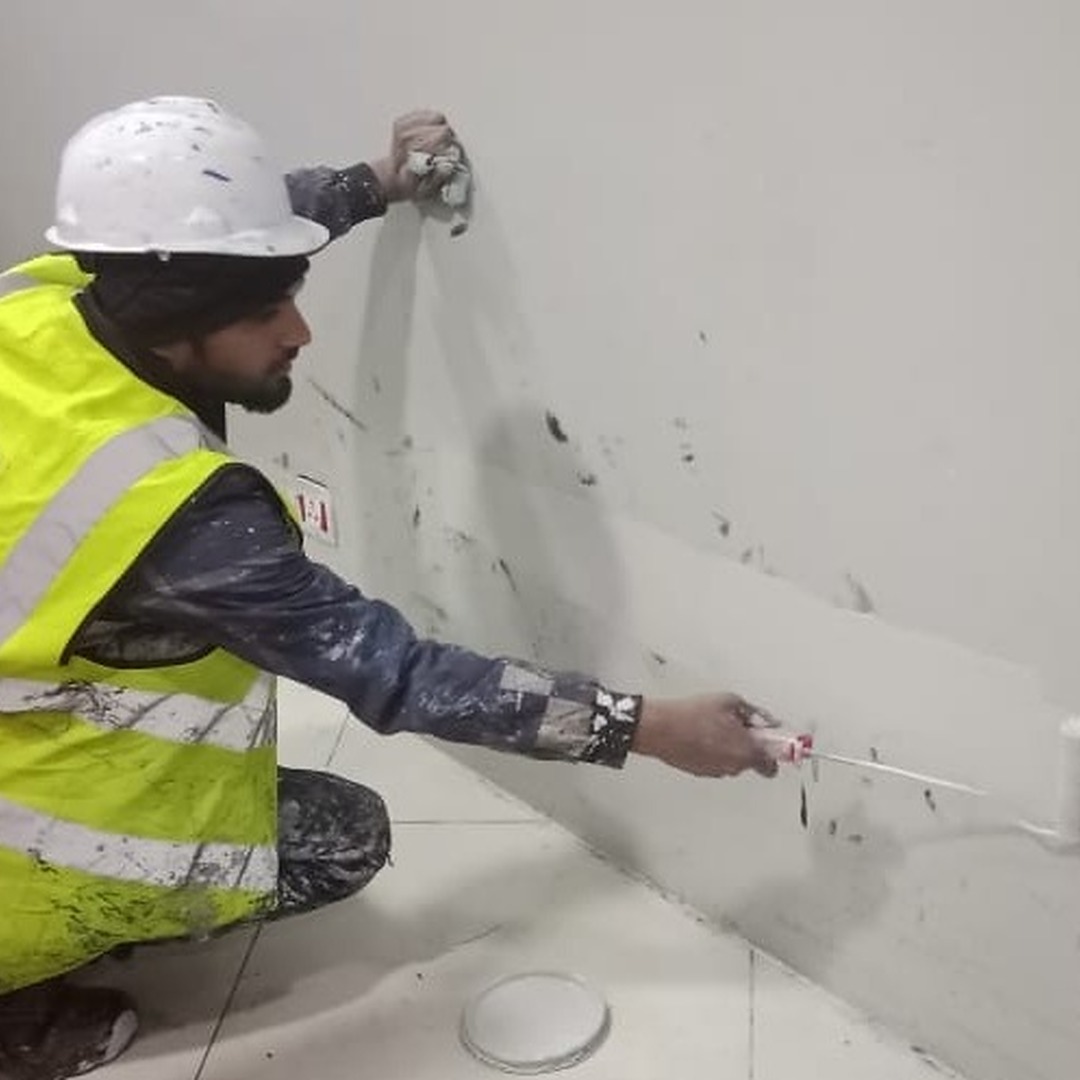 Painter using a roller brush to paint a wall